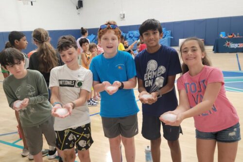 Group of kids holding ice in their hands in a gym