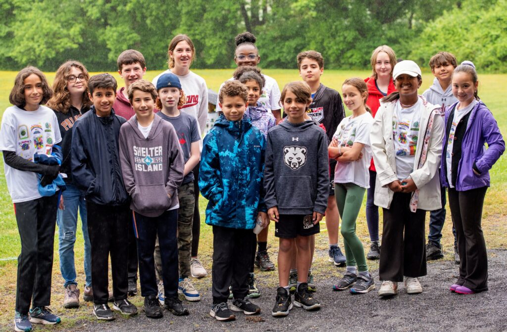 Several young alums look at the camera at an outdoor event